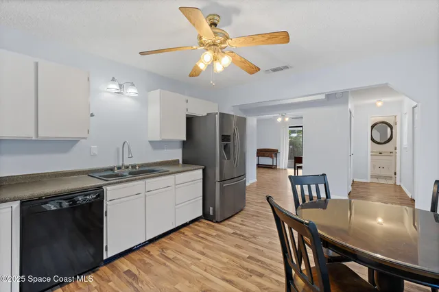 a kitchen with stainless steel appliances granite countertop a stove a refrigerator a kitchen island a dining table and chairs