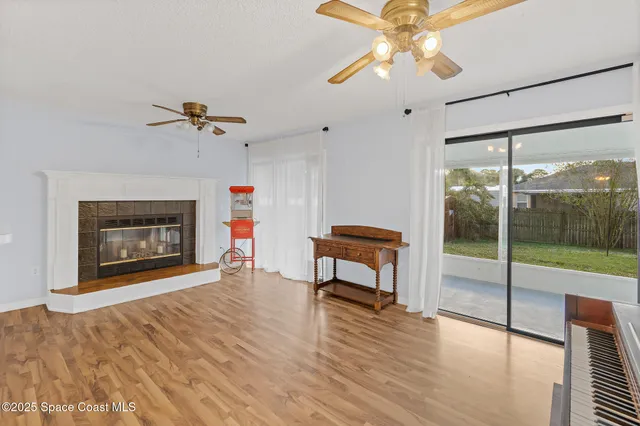 a view of livingroom with furniture wooden floor fan and a fireplace
