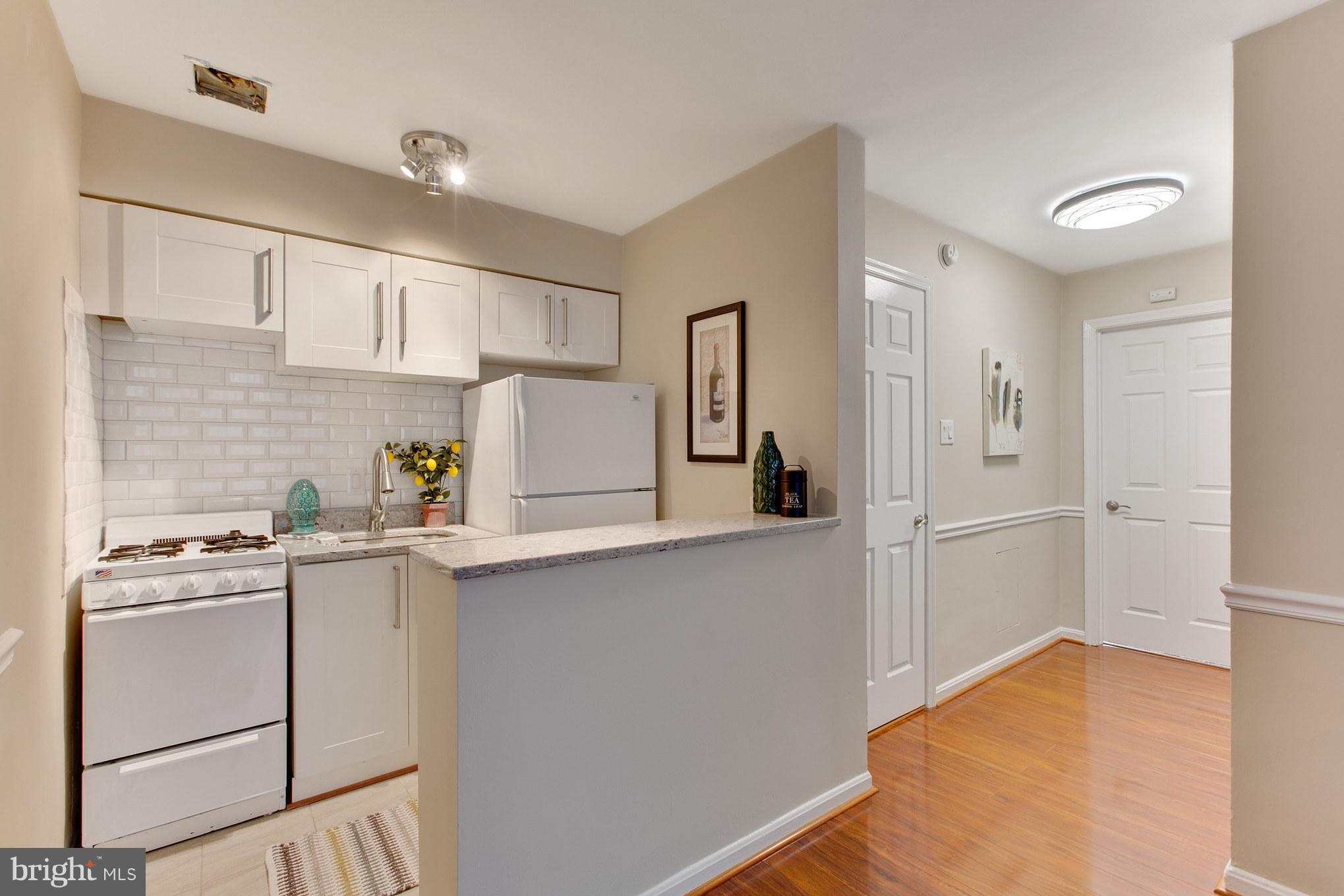 513 12th Street Northeast, Unit 3 Washington, DC 20002 - Photo 5 of 11 a kitchen with white cabinets and white appliances