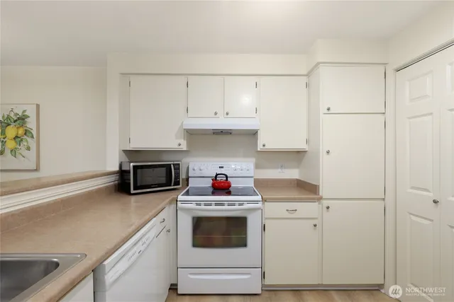 a kitchen with white cabinets and white appliances