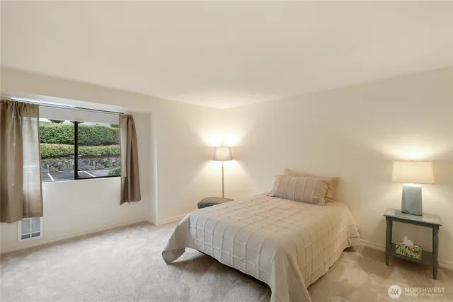 a bedroom with a bed and a large window