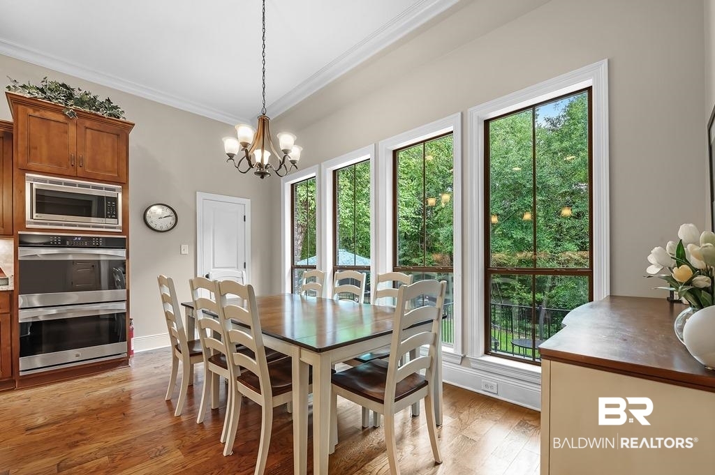 30014 Dolive Ridge Daphne, AL 36527 - Photo 24 of 57 Dining space featuring a wealth of natural light, a notable chandelier, ornamental molding, and light hardwood / wood-style floors