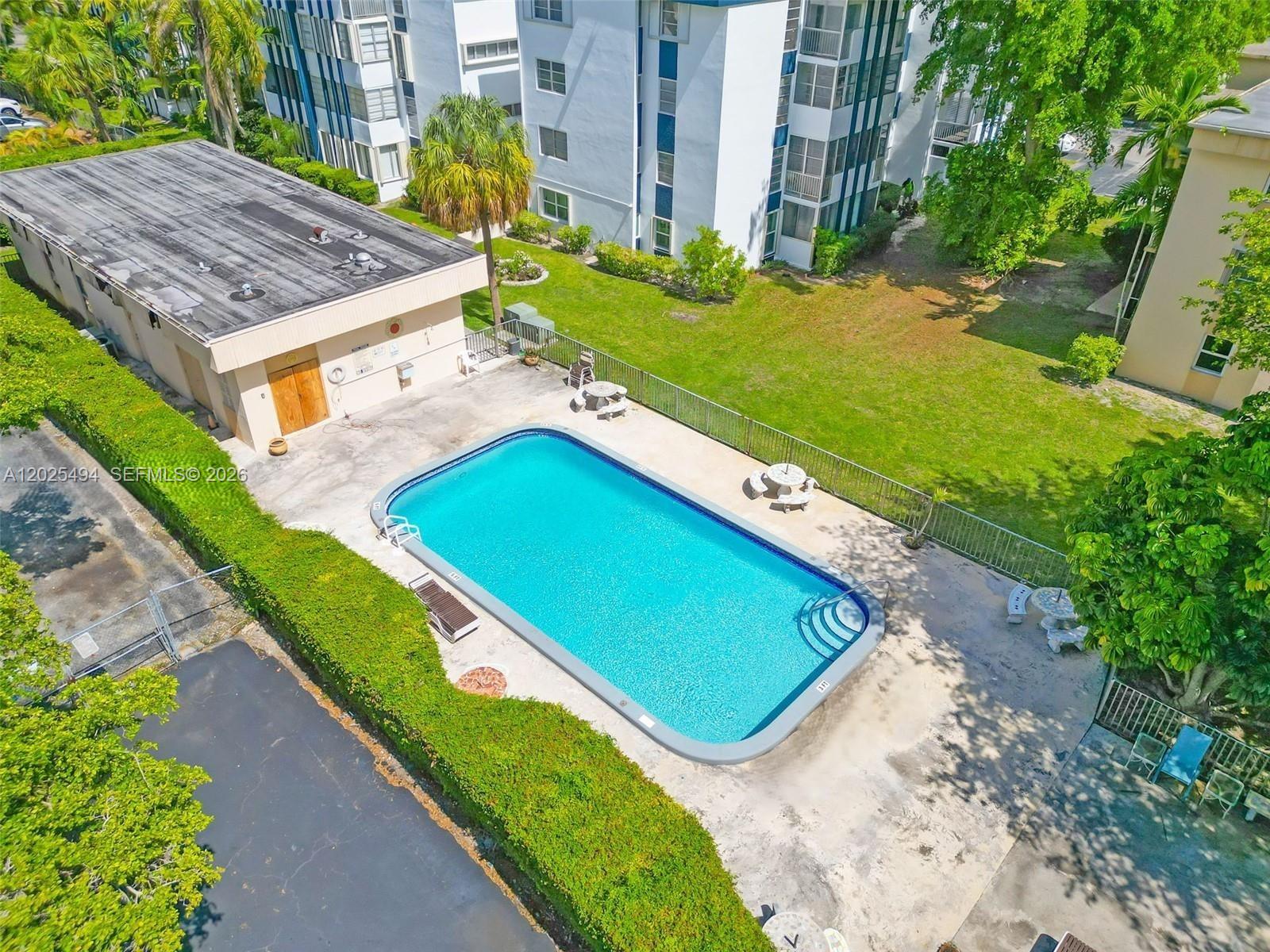 9159 Southwest 77th Avenue, Unit 112 Miami, FL 33156 - Photo 37 of 38 an aerial view of a tennis ground with a large pool