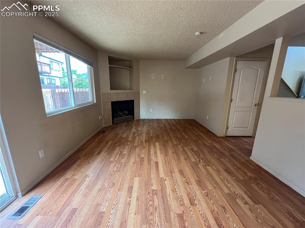 718 Mediterranean Point Colorado Springs, CO 80910 - Photo 8 of 28 wooden floor in an empty room with a window