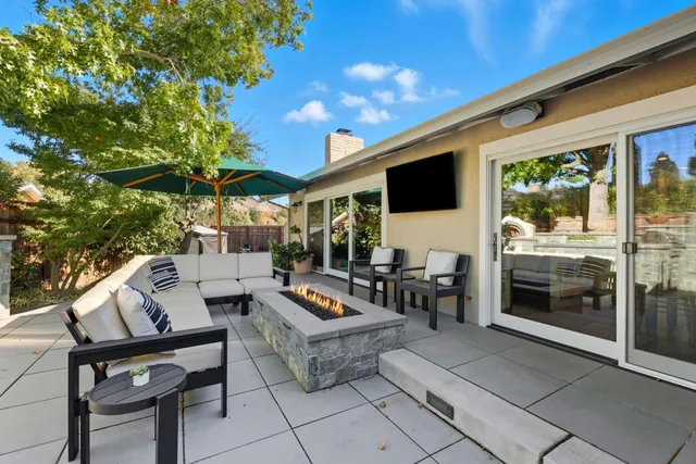 a outdoor space with the couches and dining table with the potted plants