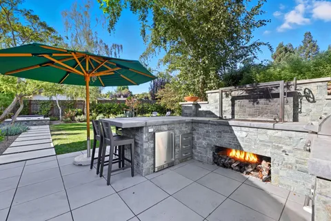 a patio with a table and chairs under an umbrella