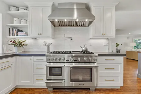 a kitchen with a stove and white cabinets
