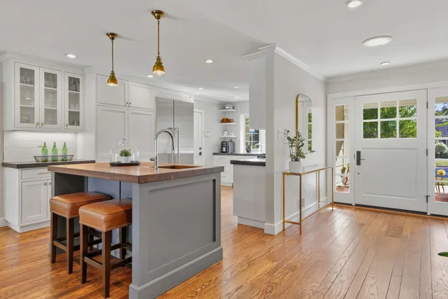 a open kitchen with granite countertop a stove a sink and a wooden floors