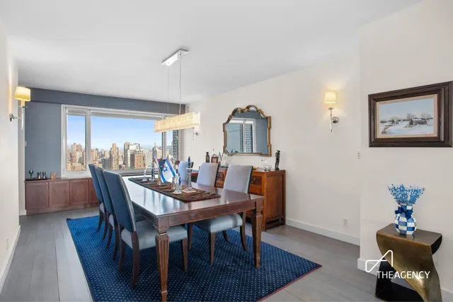 a kitchen with stainless steel appliances granite countertop a sink dishwasher a stove a refrigerator a dining table and chairs with wooden floor