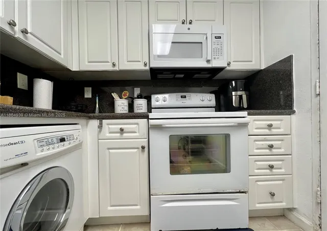 a kitchen with granite countertop a stove and a microwave oven