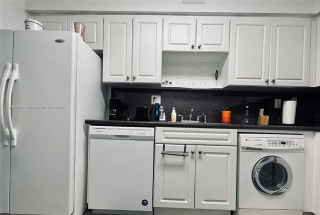 a kitchen with cabinets and a refrigerator