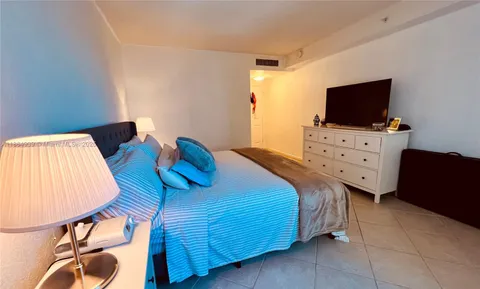 a bedroom with a bed and flat screen tv