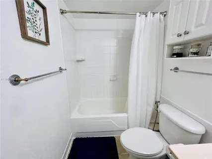 a white toilet sitting next to a bath tub