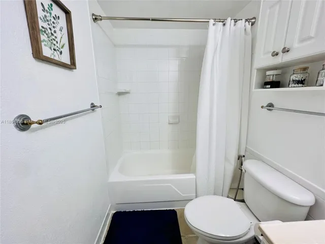 a white toilet sitting next to a bath tub
