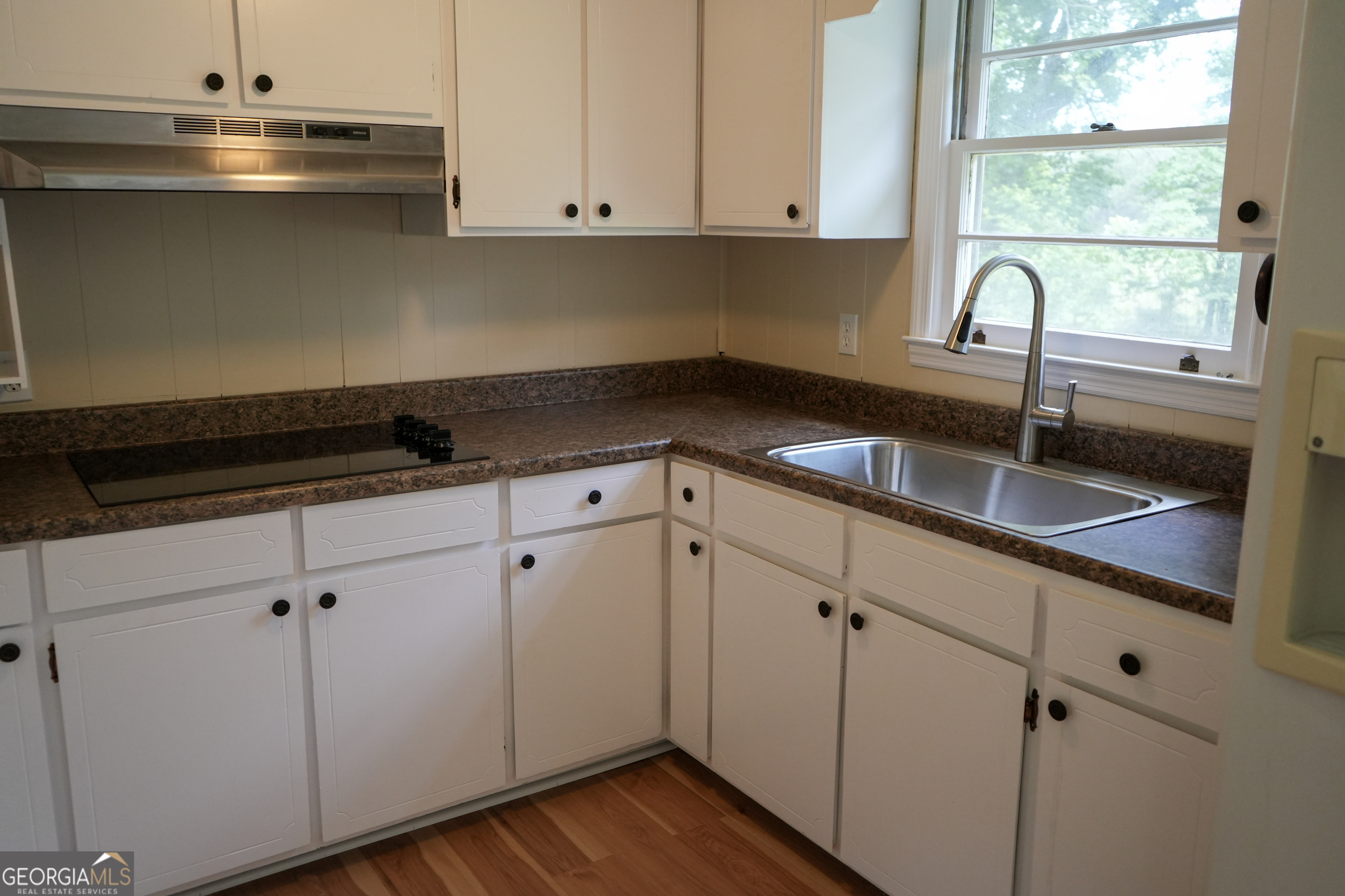 1869 Minter Blue Springs Road Rockledge, GA 30454 - Photo 25 of 45 a kitchen with granite countertop white cabinets and a sink