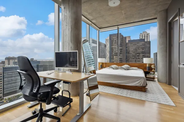 a bedroom with a large window and a balcony