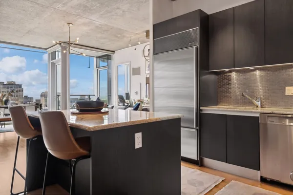 a kitchen with stainless steel appliances kitchen island granite countertop a refrigerator and a stove top oven