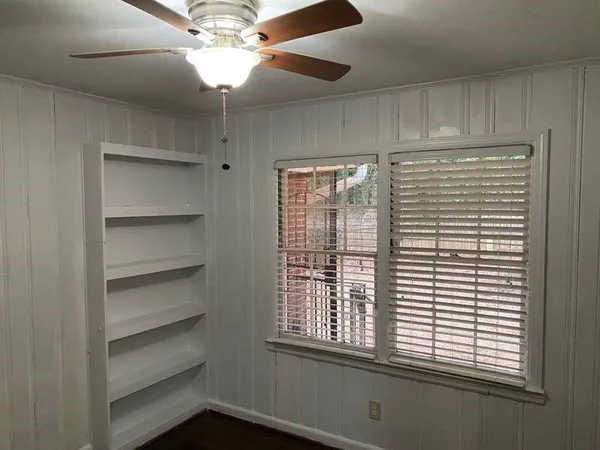 a view of a room with a window and a ceiling fan
