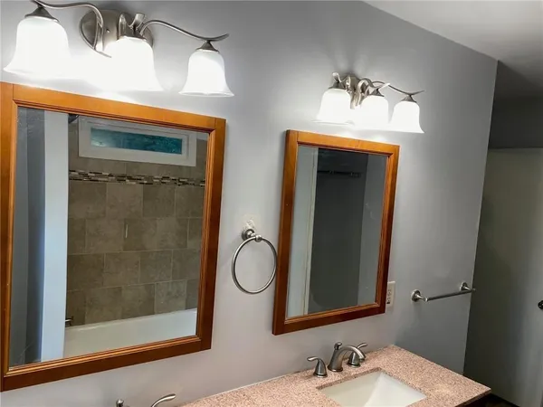 a bathroom with a mirror sink and shower