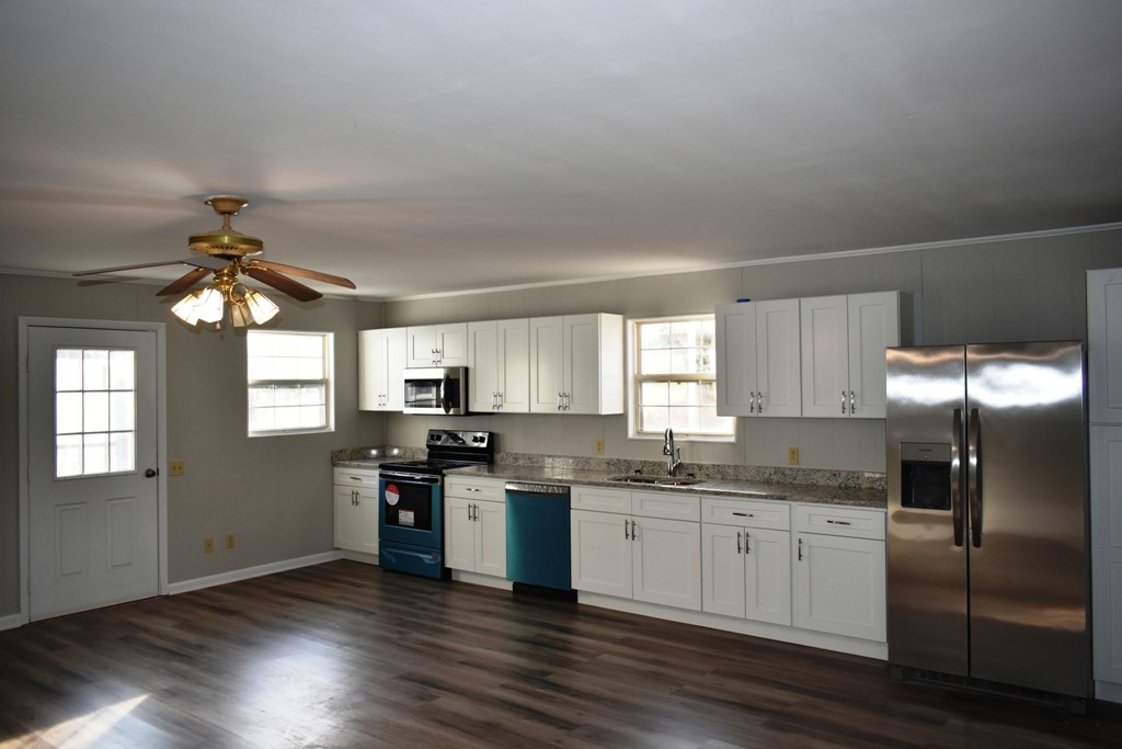 5 Dog Branch Road Pleasant Shade, TN 37145 - Photo 2 of 8 a kitchen with stainless steel appliances granite countertop a stove a sink dishwasher a refrigerator and white cabinets with wooden floor