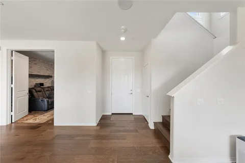 a view of a hallway with wooden floor and closet