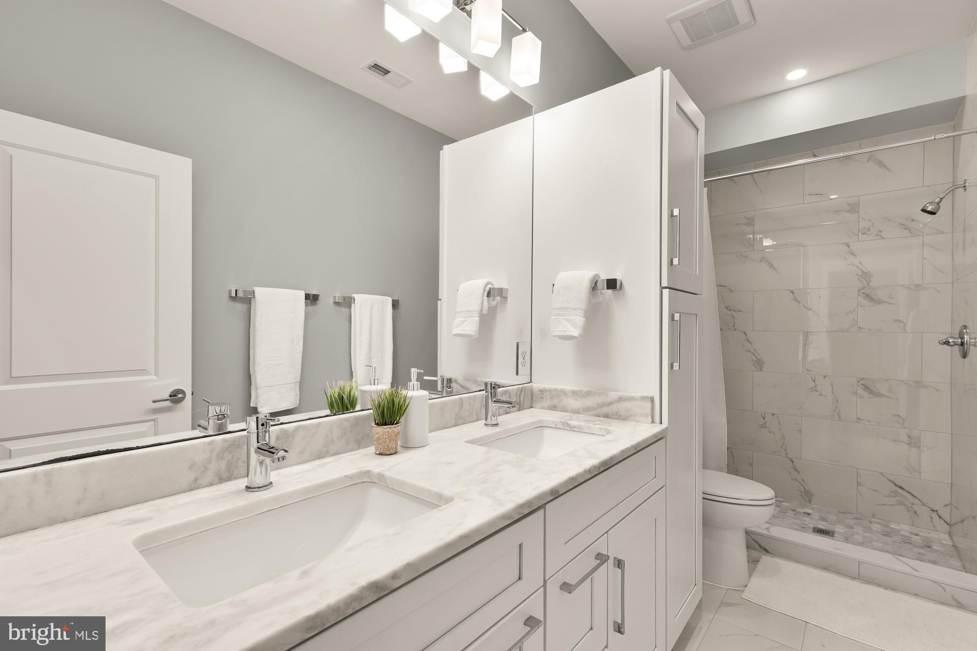 1719 Lincoln Road Northeast, Unit 1 Washington, DC 20002 - Photo 20 of 23 a bathroom with a double vanity sink mirror double and shower