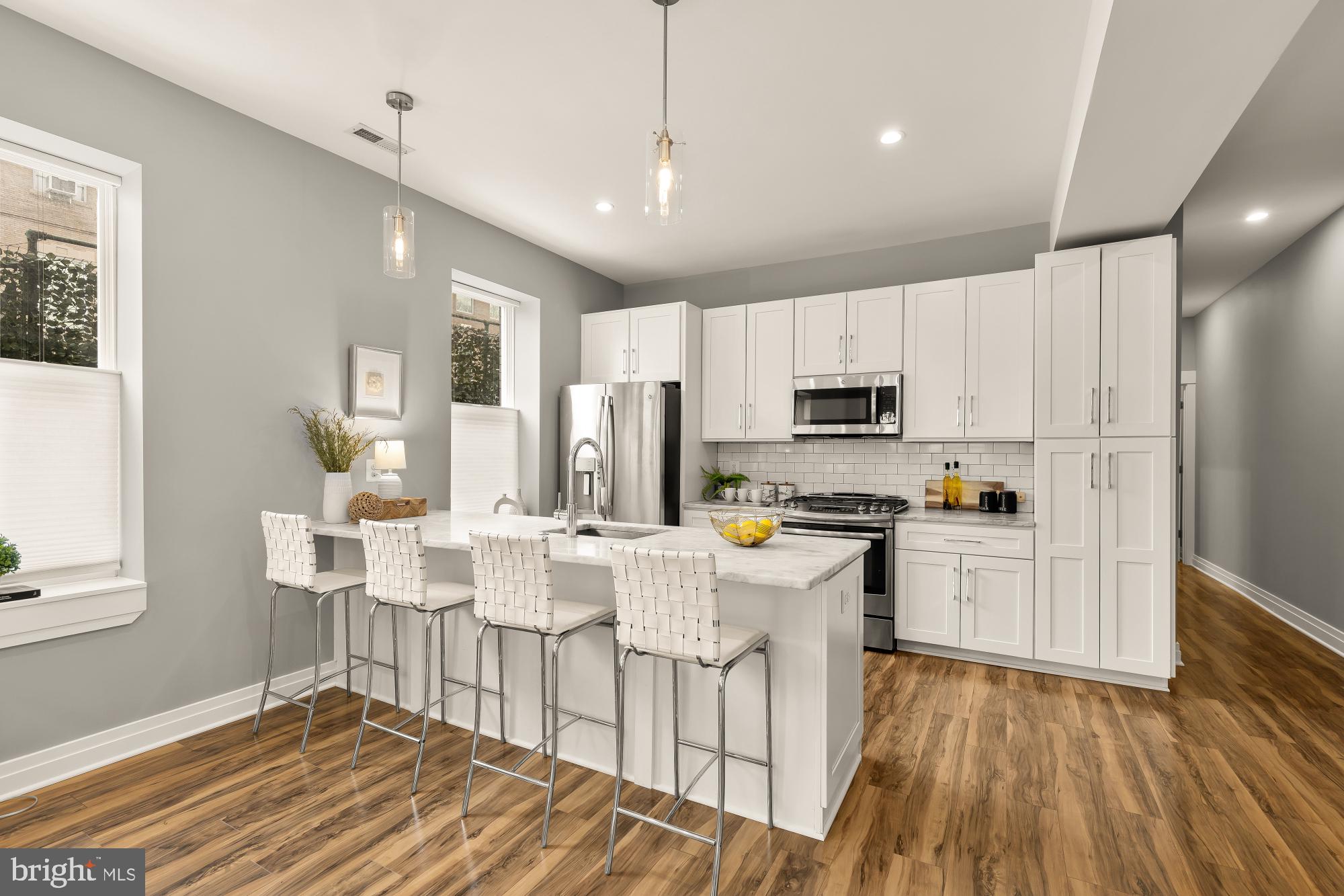 1719 Lincoln Road Northeast, Unit 1 Washington, DC 20002 - Photo 6 of 23 a kitchen with stainless steel appliances granite countertop a refrigerator a stove top oven a sink dishwasher and white cabinets with wooden floor