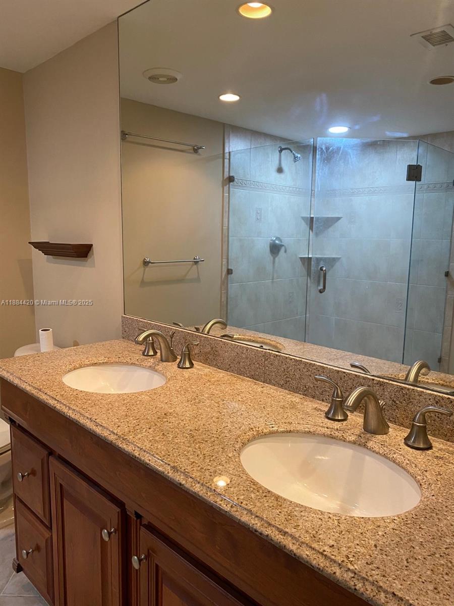 4200 North Ocean Drive, Unit 11103 Riviera Beach, FL 33404 - Photo 8 of 11 a bathroom with a granite countertop sink and a mirror