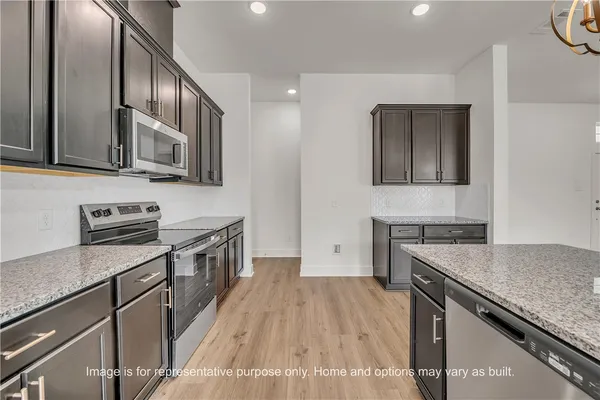 a kitchen with granite countertop wooden cabinets and stainless steel appliances