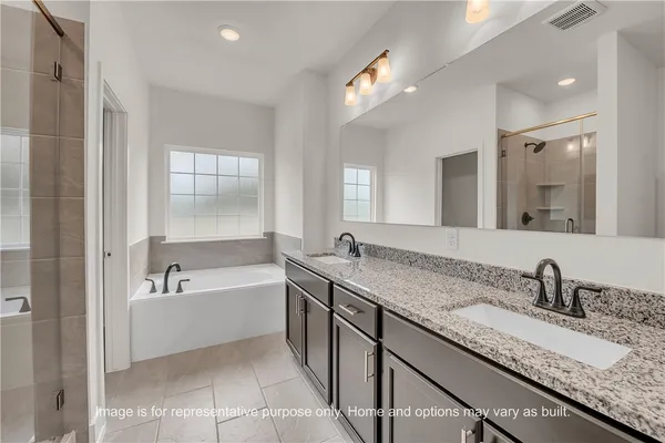 a bathroom with a granite countertop bathtub sink double and mirror