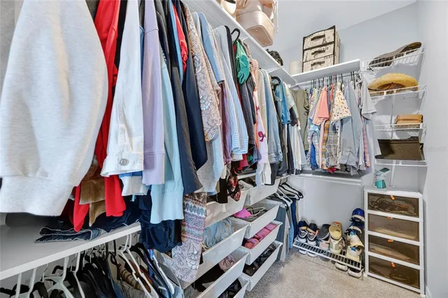 a view of walk in closet with clothes and shoes