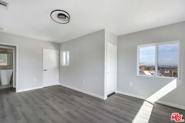 a view of an empty room with wooden floor