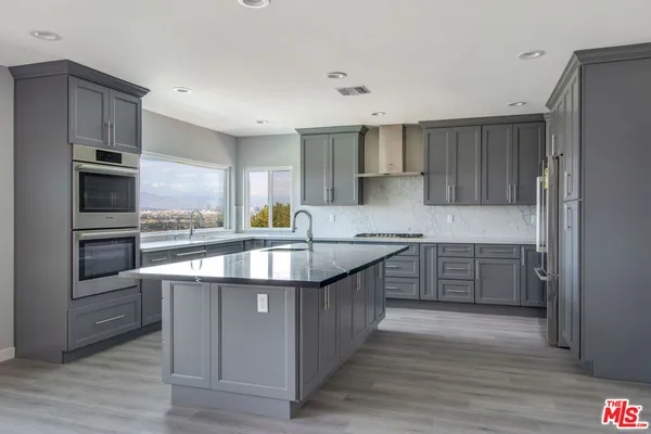 a large kitchen with stainless steel appliances granite countertop a large counter top and a stove