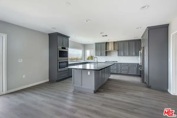 a kitchen with stainless steel appliances granite countertop a sink and a stove top oven
