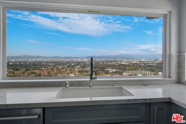 a view of a kitchen with a sink and wooden floor