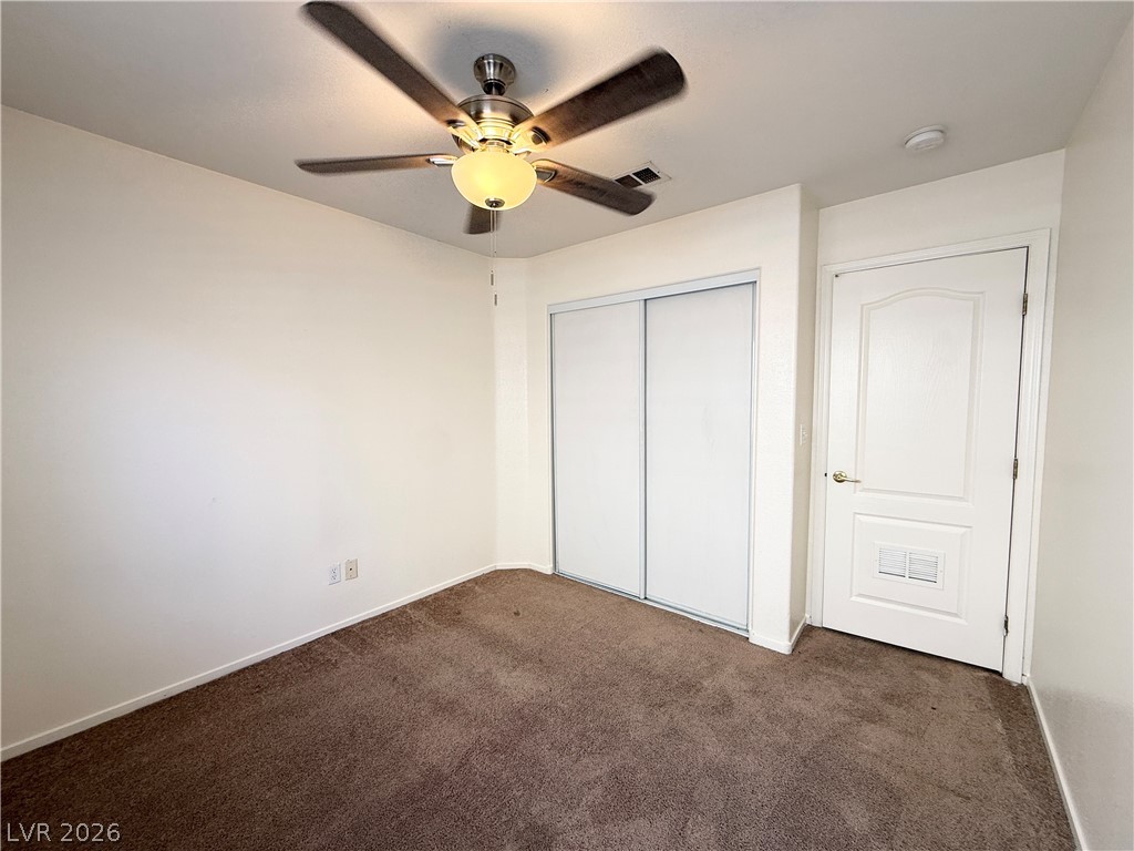 8870 Haviland Road Las Vegas, NV 89123 - Photo 11 of 24 Comfortable carpeted bedroom with a practical ceiling fan and generous closet storage.