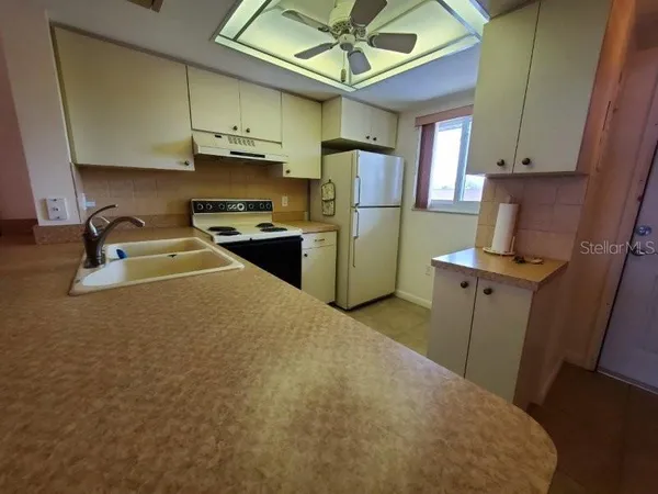 a kitchen with a refrigerator a stove top oven a sink and dishwasher
