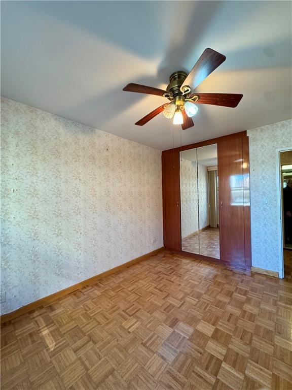458 Neptune Avenue, Unit 3K Brooklyn, NY 11224 - Photo 3 of 12 an empty room with closet and a chandelier fan