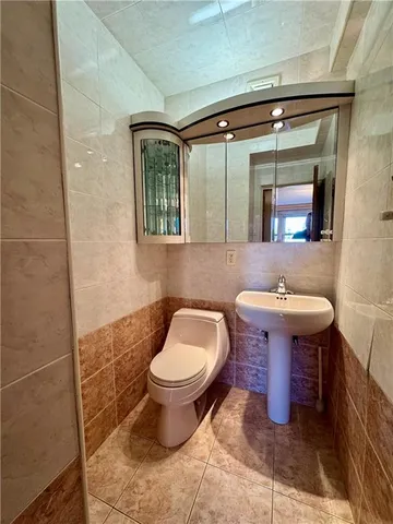 a bathroom with a toilet sink and mirror