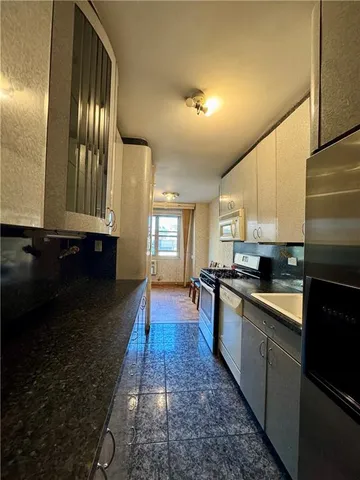 a kitchen with stainless steel appliances granite countertop a stove a sink and a microwave