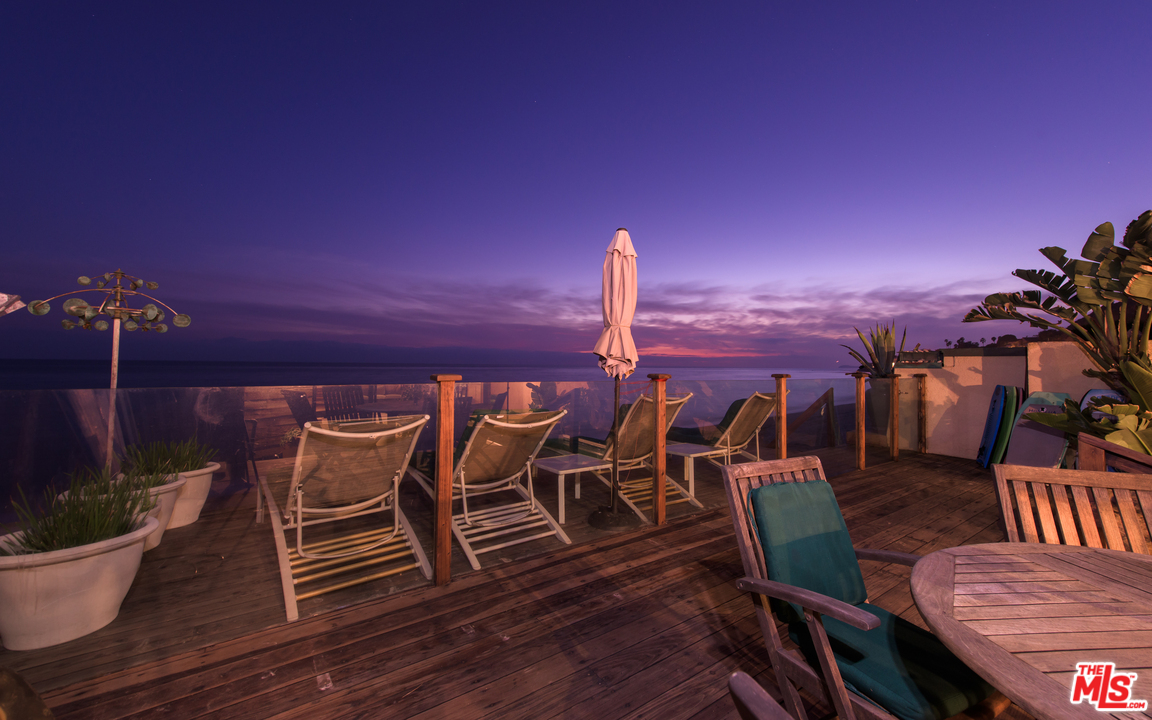 23768 Malibu Road Malibu, CA 90265 - Photo 3 of 23 a view of a roof deck with table and chairs couches with wooden floor and city view