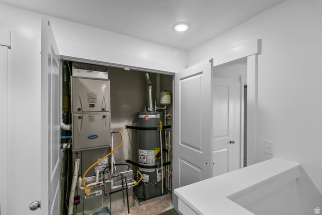 3014 South 265th Street West Logan, UT 84321 - Photo 19 of 25 Dedicated utility closet featuring a Carrier furnace and a Rheem water heater