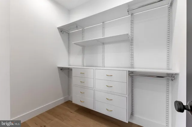 a view of empty room with wooden floor and ceiling fan