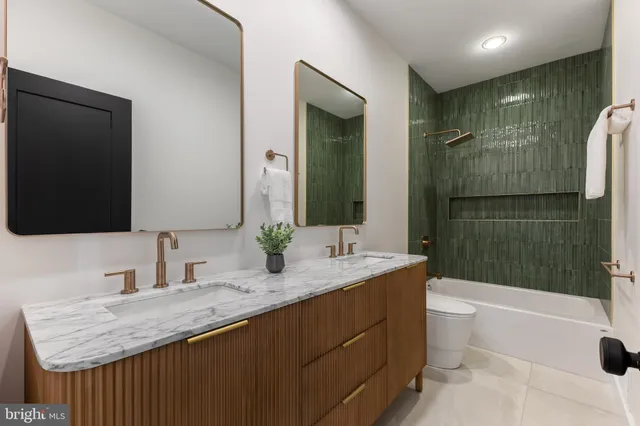 a bathroom with a bathtub shower sink mirror and toilet
