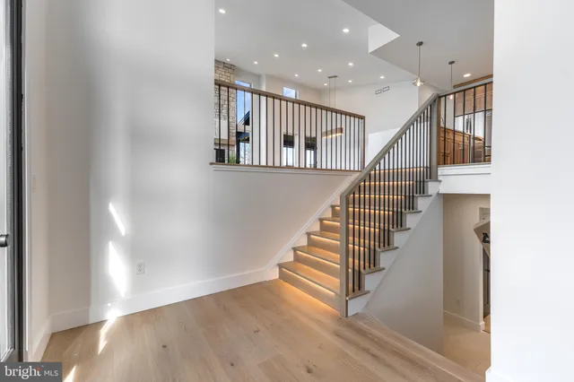 a view of an empty room with kitchen and a window