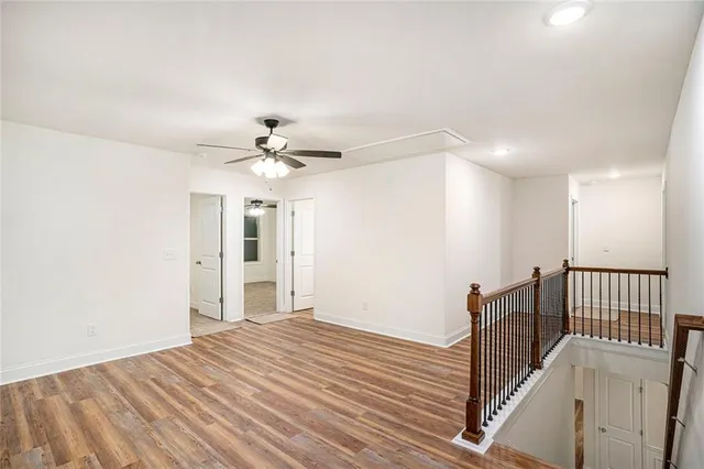 a view of a livingroom with wooden floor and a ceiling fan