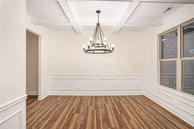 a view of empty room with wooden floor and window