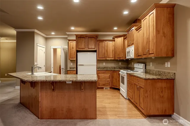 a kitchen with stainless steel appliances granite countertop a sink a stove and a refrigerator