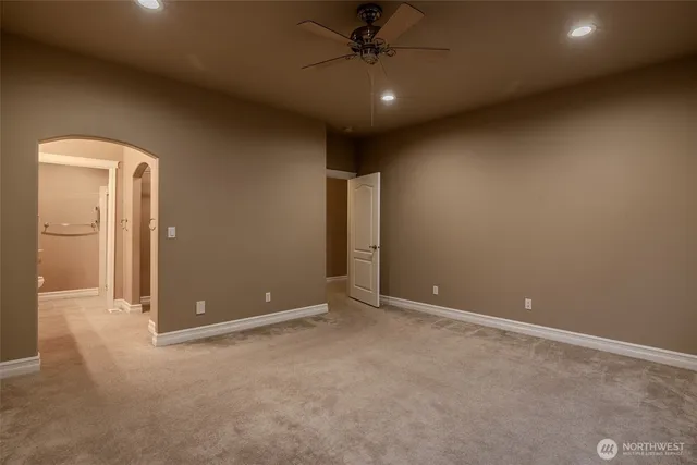 an empty room with closet and windows