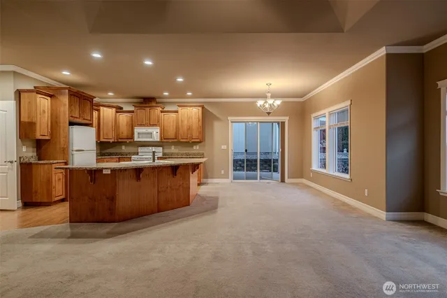 a kitchen with stainless steel appliances kitchen island granite countertop a stove and a refrigerator